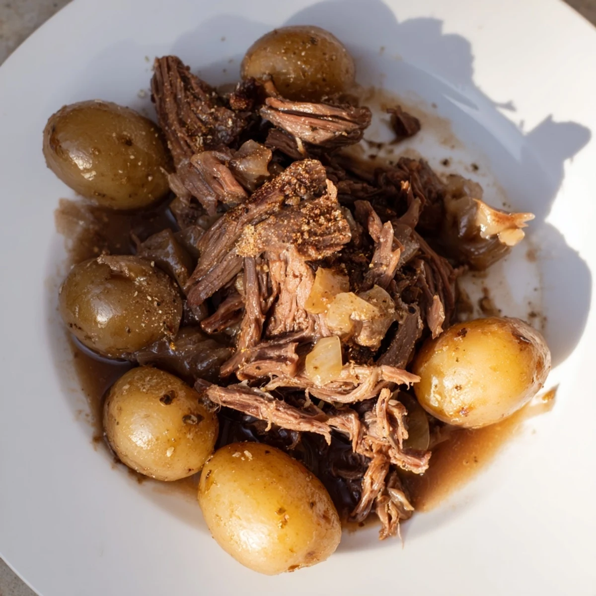 Tender, juicy slow cooker pot roast served with potatoes, ready for a hearty family dinner.