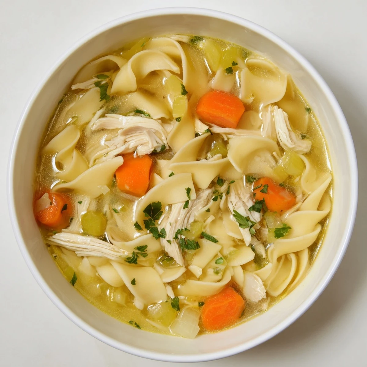 Hearty Cozy Chicken Noodle Soup is ready, complete with fresh parsley and delicious, tender chicken.