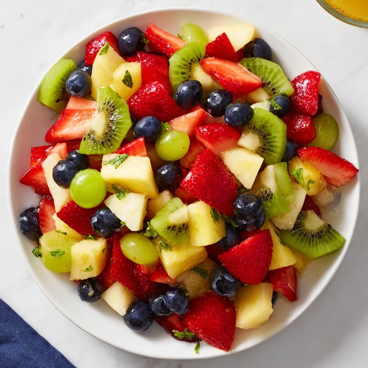 This light and healthy fruit salad, beautifully tossed, features a bright, zesty honey-lime glaze.