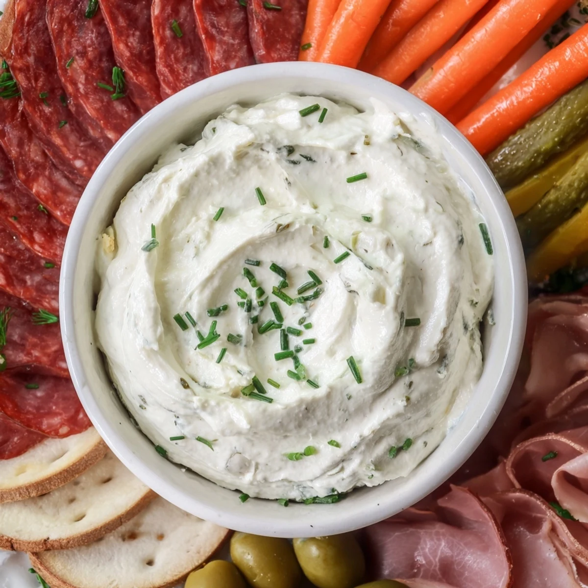 This stunning Compass Rose appetizer showcases cured meats arranged around a savory cream cheese center.