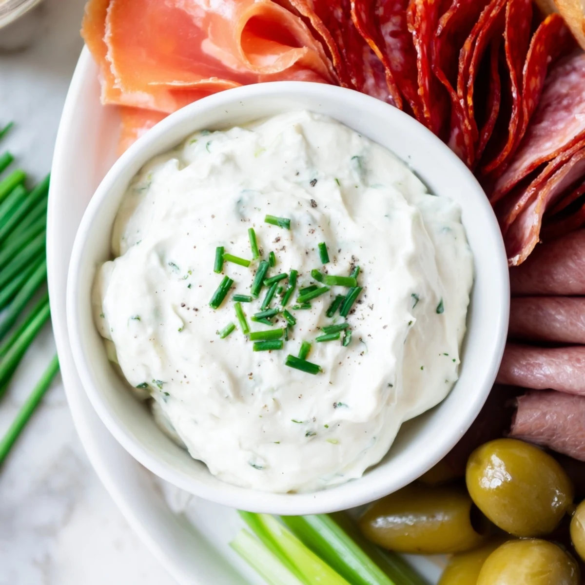 The Compass Rose appetizer features an array of meats encircling a creamy, flavorful central dip.