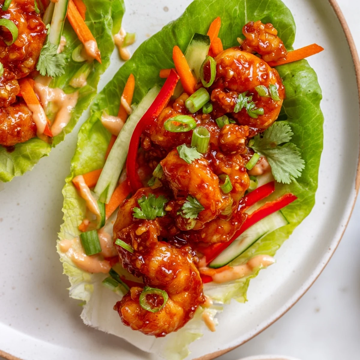 Vibrant shrimp lettuce cups filled with spicy cooked shrimp, crunchy veggies, and creamy sauce.