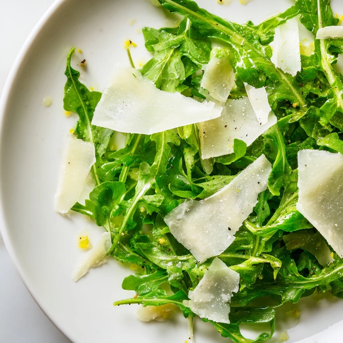 Fresh arugula salad with a bright lemon dressing, Parmesan cheese, and thinly sliced shallots.