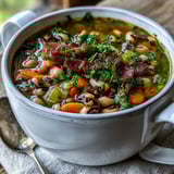 Hearty Black-Eyed Peas and Bacon Soup simmering in a rustic pot with a side of cornbread.