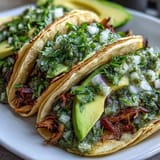 Tender shredded chicken salsa verde tacos piled high with fresh toppings.