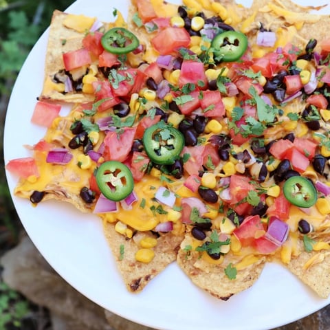 Sheet pan nachos, sizzling with melted cheese, vibrant toppings, ready to enjoy together.