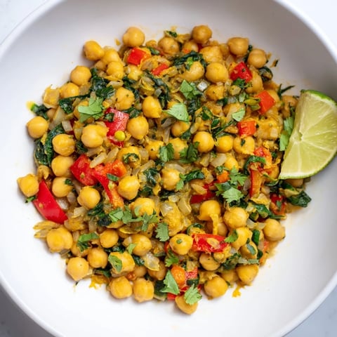 Creamy Chickpea Curry in a pot, garnished with fresh cilantro and a squeeze of lime.
