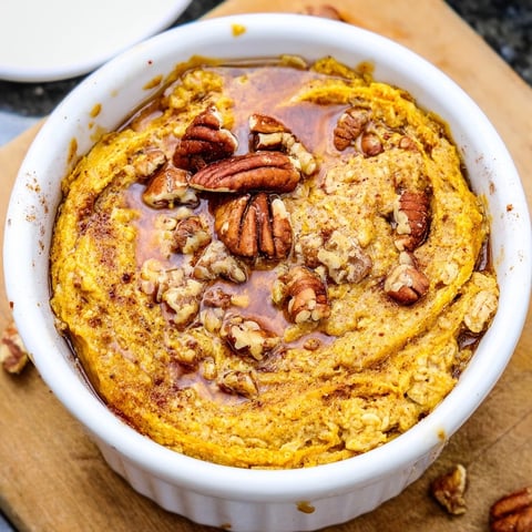 Warm, golden pumpkin spice baked oats, perfect for a cozy fall breakfast with delightful textures.