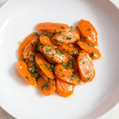 Golden Honey-Glazed Carrots glistening with a sweet, golden glaze, perfect as a vibrant side dish.