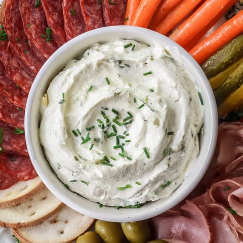 This stunning Compass Rose appetizer showcases cured meats arranged around a savory cream cheese center.