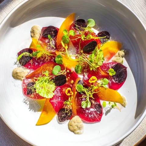 This artistic The Shadow Play showcases dark blackberries against colorful beets and a flavorful tahini drizzle.