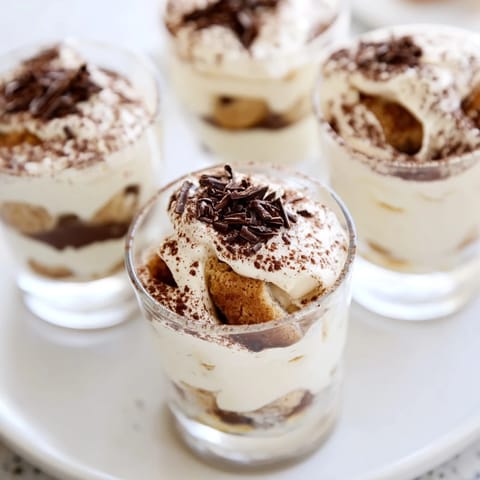 Elegant deconstructed tiramisu shots, with cocoa dusting and dark chocolate shavings, perfect dessert.