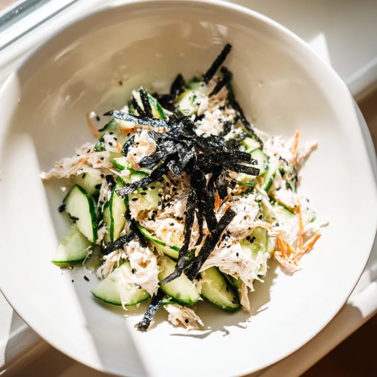 Freshly made California Roll Cucumber Salad topped with nori strips and pickled ginger, perfect for a light summer meal.