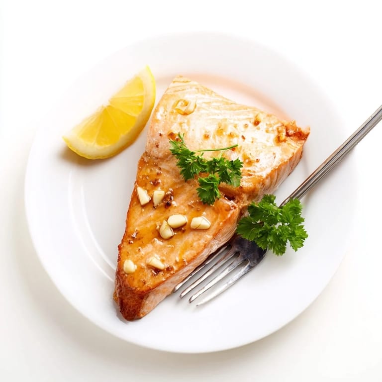 Golden-brown Honey Garlic Glazed Salmon fillets, brushed with a buttery honey sauce and roasted to tender perfection on a baking tray.