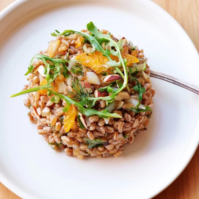 Freshly prepared Farro Salad With Fennel, Oranges, and Almonds, featuring creamy citrus vinaigrette drizzled over the wholesome Mediterranean-inspired ingredients.  